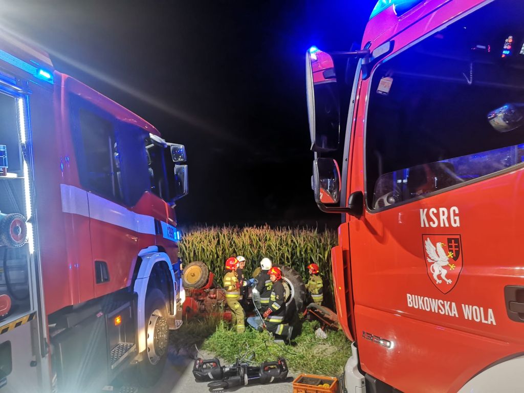 Mężczyzna zmarł pod wywróconym ciągnikiem z kosiarką, Dziewięcioły, Łukasz Krzywda, KP PSP w Miechowie