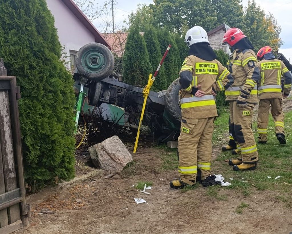 wypadek, wywrócony ciągnik, ranny mężczyzna, przygniecenie