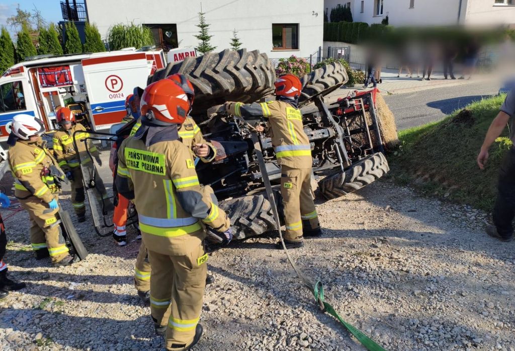 wypadek, wywrócony ciągnik, ranny traktorzysta, bela słomy