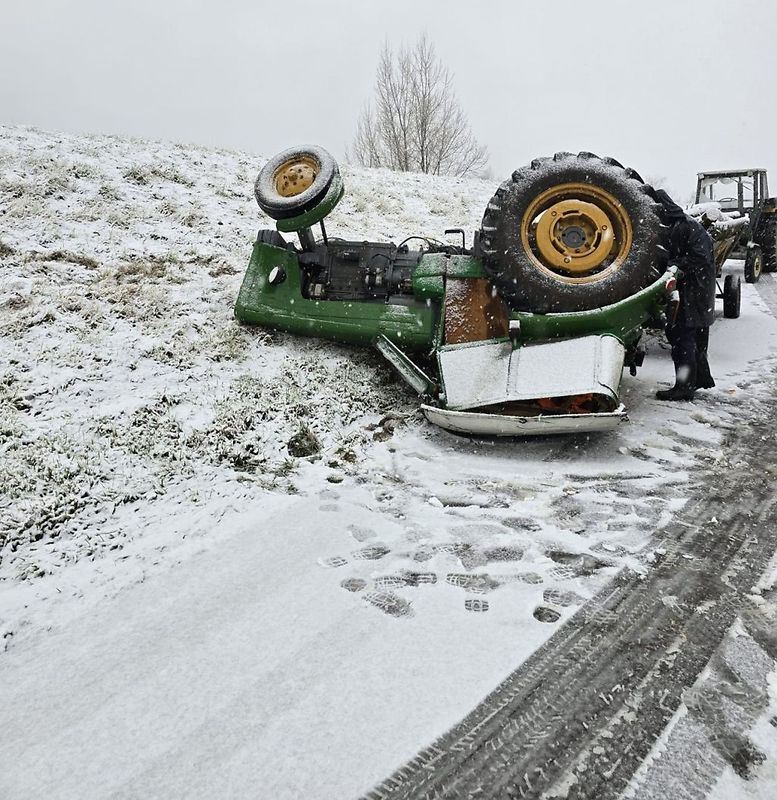 Ciągnik z zaczepioną przyczepą z drewnem wpadł w poślizg na oblodzonej drodze. W efekcie tego maszyna dachowała. Fot. KPP Staszów